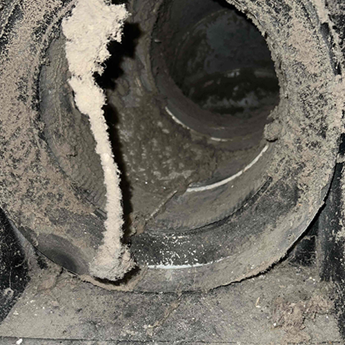 Before Duct Cleaning Interior of air duct coated in a layer of dust